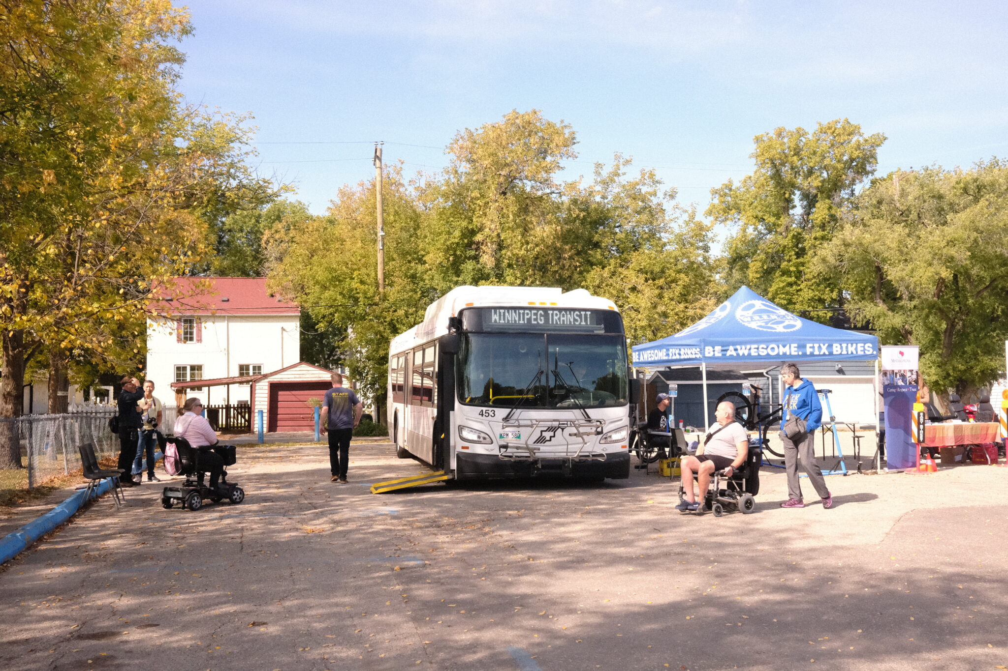Visitors walk and roll by a Winnipeg Transit bus 