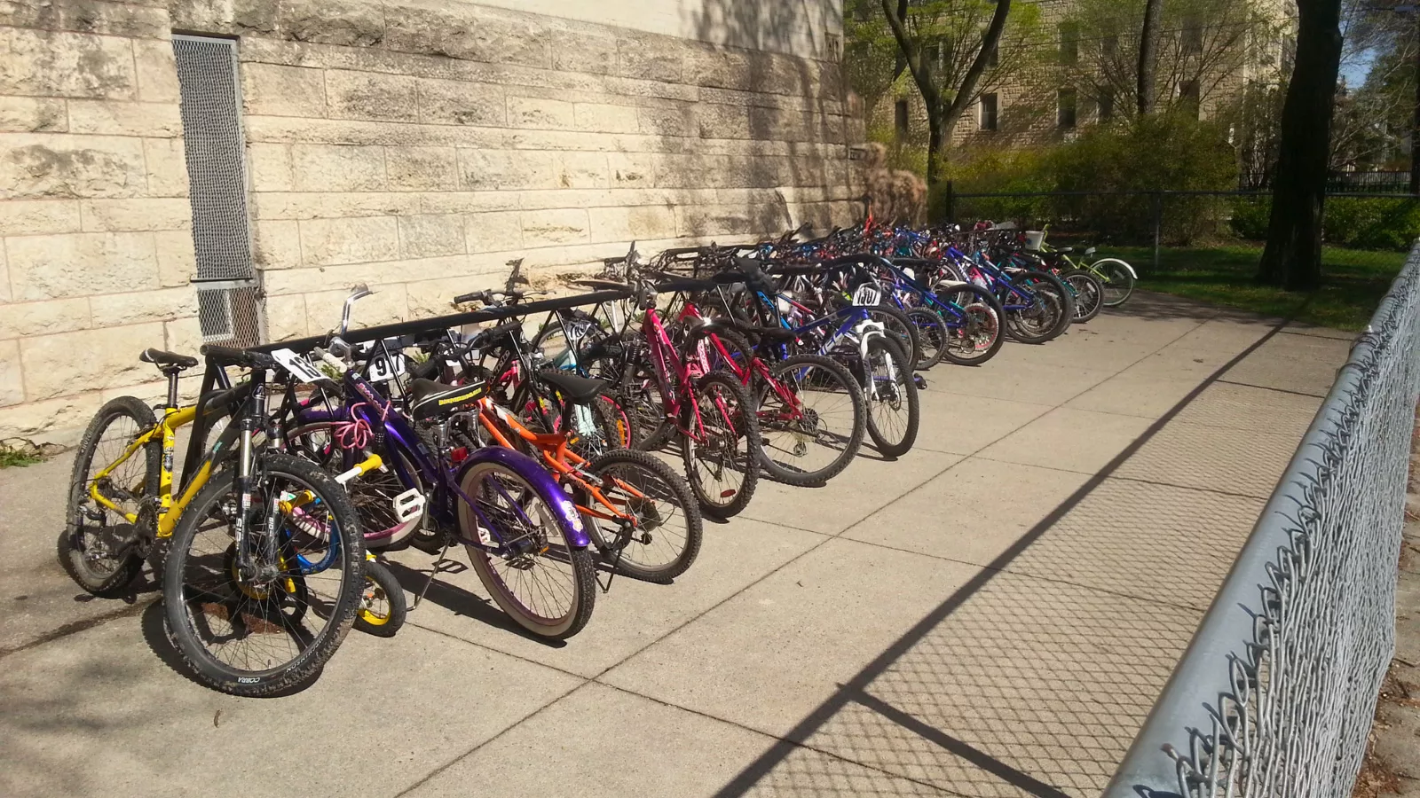 bicycles lined up in a bicycle stand outdoors in the sunshine