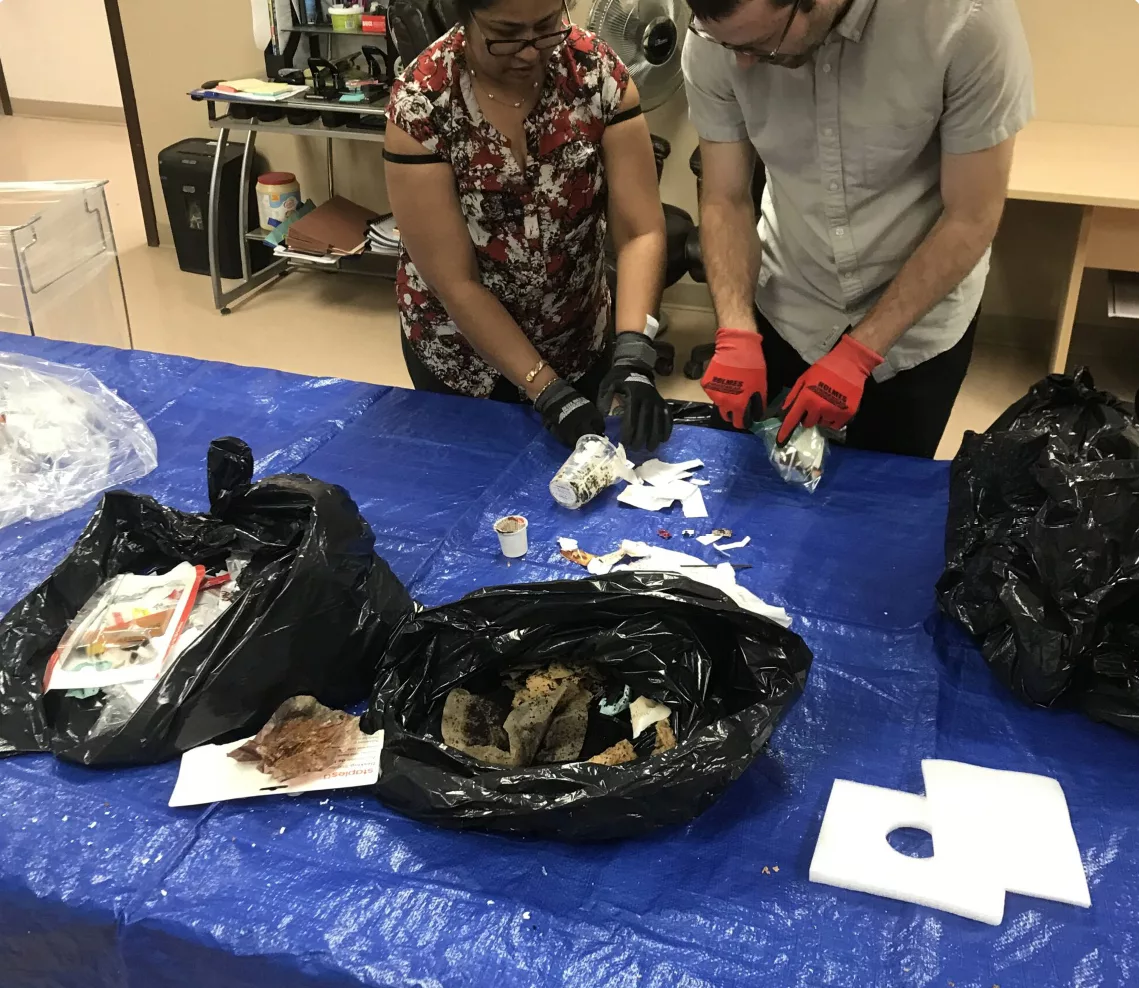 people wearing gloves reviewing waste and recyclables