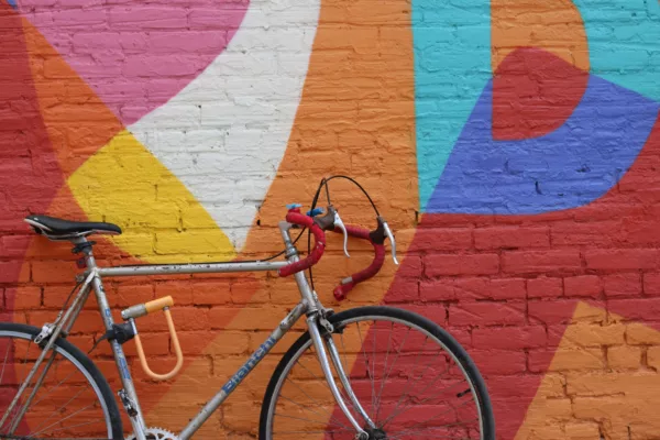 bicycle leaning against brightly painted brick wall