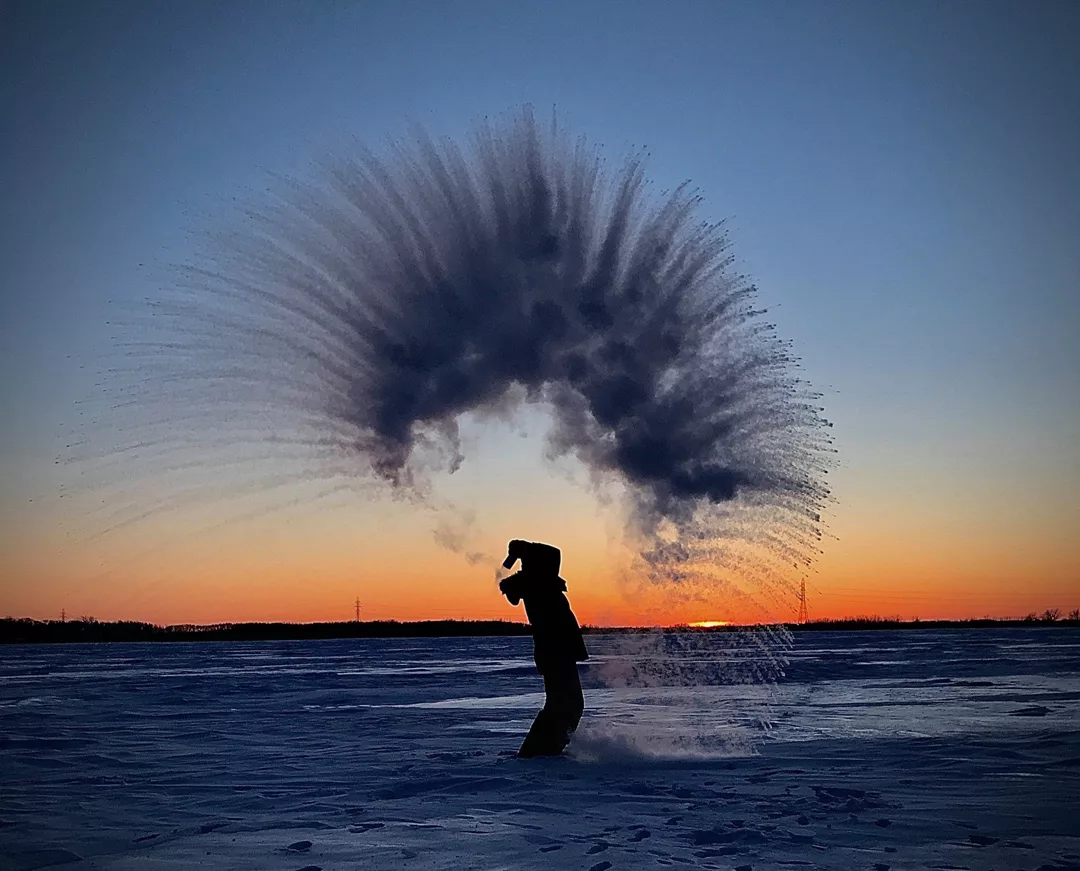 water freezing in the air when it is tossed into the sky over a person's head