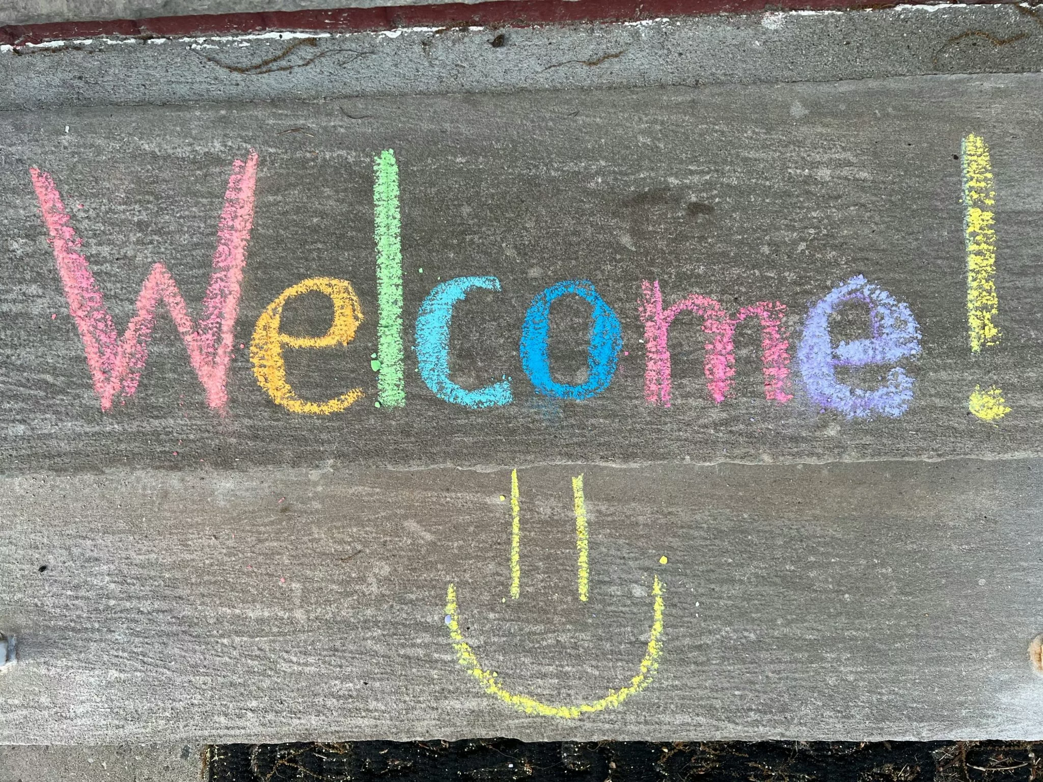 welcome written in colourful chalk