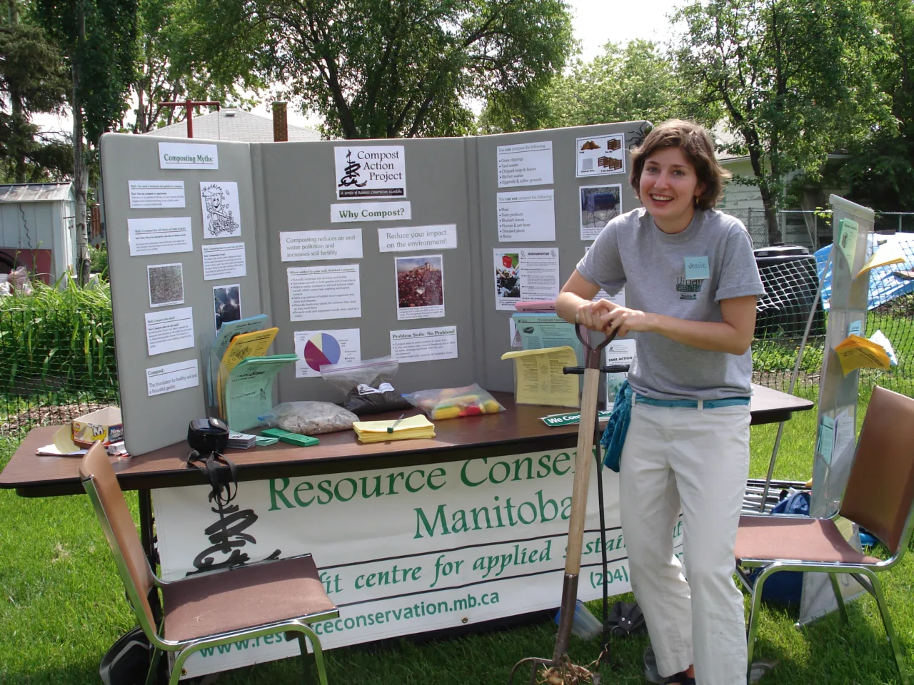 Person standing in front of a folder board displace with a banner that says Resource Conservation Manitoba